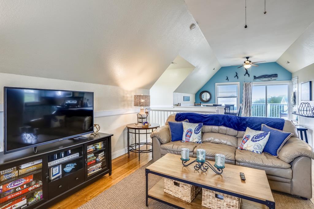Settle into this inviting living space with a comfy leather sofa, big screen TV, and charming coastal touches, perfect for unwinding after a day of adventure.