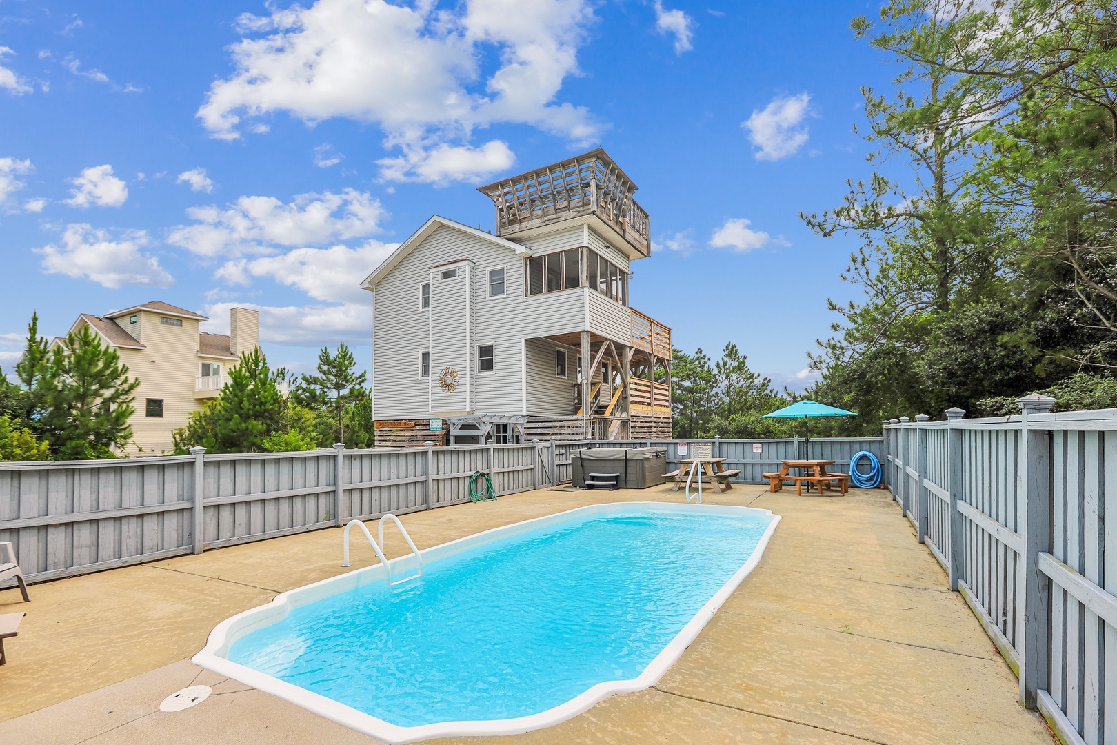 A private outdoor pool with your own spacious deck area, perfect for soaking up the sun and enjoying the bright blue sky overhead.