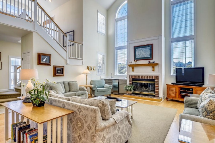 Picture yourself unwinding here, soaking in the natural light that floods this airy living space. Tall ceilings and comfortable seating invite you to relax by the fireplace after your daily adventures.