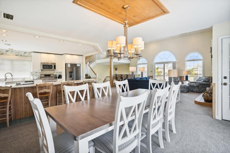 Gather around this inviting dining table where you can share meals and memories with your group. The open layout connects you to the kitchen and living spaces, creating a warm, welcoming atmosphere for your stay.