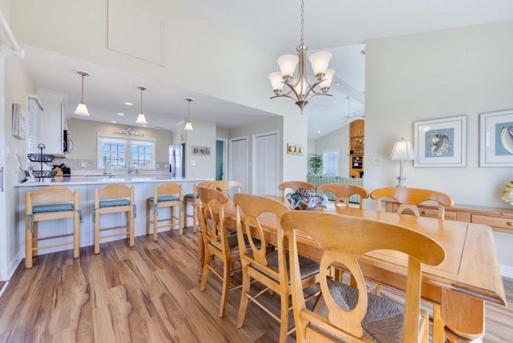 Step into this inviting open-concept space where your group can gather around the spacious dining table, chat at the breakfast bar, or relax in the living area—all bathed in natural light and coastal charm.