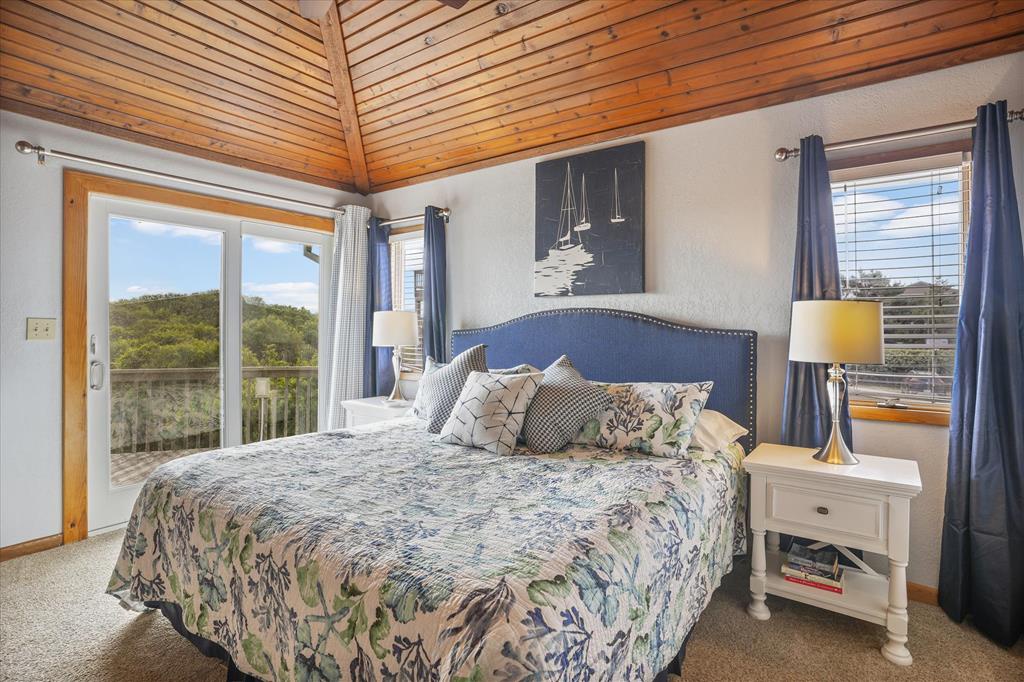 Sink into your cozy bed beneath soaring wood-planked ceilings while natural light pours in through double doors and windows. Step outside to your private deck with peaceful treetop views anytime.