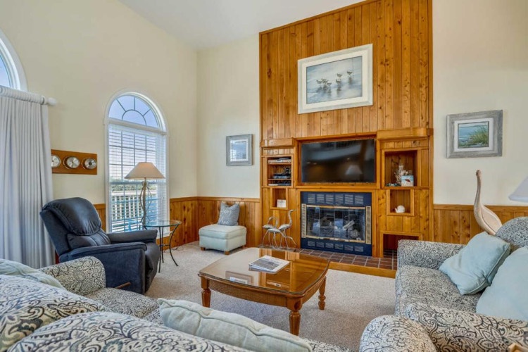 Sink into plush seating by the fireplace and enjoy your favorite shows on the mounted TV. The warm wood accents and abundant natural light create the perfect space to unwind after a day of adventure.