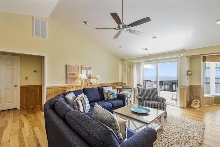 Step into your bright and airy living space, where vaulted ceilings, cozy seating, and soft coastal tones invite you to unwind and make yourself at home.