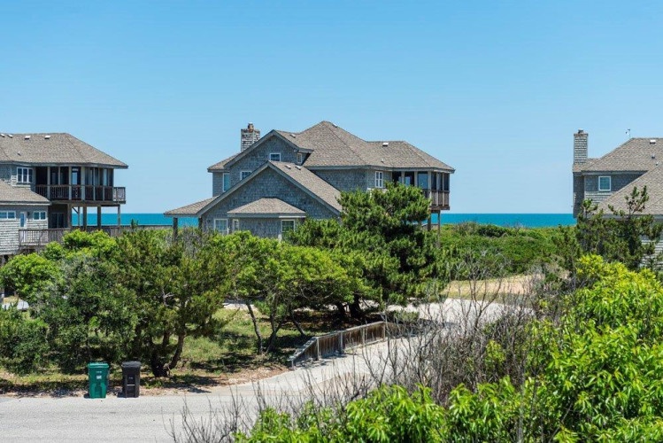 Coastal property nestled near the shoreline with beach access, surrounded by natural dunes and maritime vegetation, offering a tranquil oceanfront setting.