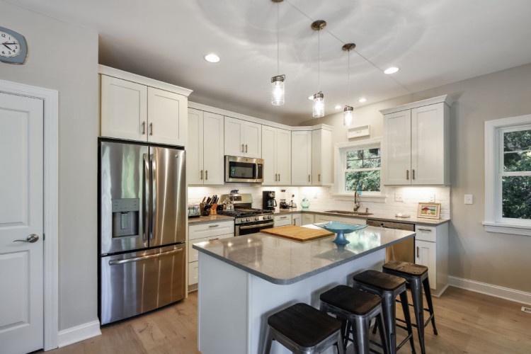 Picture yourself cooking in this bright, fully-equipped kitchen with gleaming appliances, ample counter space, and a welcoming island where morning coffee or evening appetizers feel effortless.