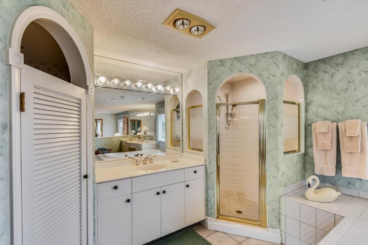 Your private ensuite awaits with a spacious walk-in shower, dual vanity, and soft pink towels—perfect for unwinding after a day of adventure.