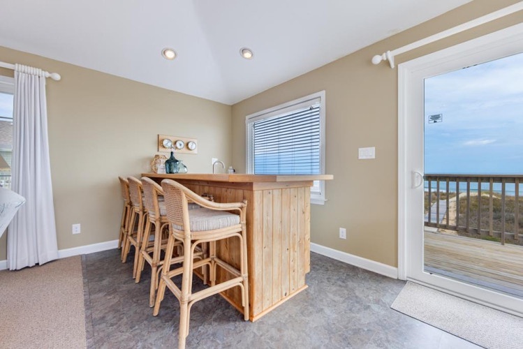 Step into your coastal breakfast nook where morning coffee meets breathtaking ocean views—your personal bar seating invites leisurely starts to beach days ahead.