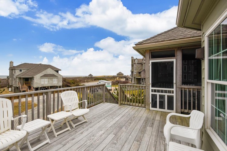 Picture yourself unwinding on this spacious deck, soaking in the coastal views as clouds drift across the blue sky. Your private outdoor retreat awaits with comfortable seating and refreshing breezes.