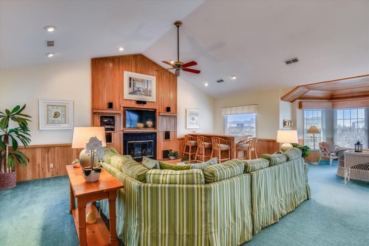 Gather with loved ones in this inviting open-concept living space, where vaulted ceilings and warm wood accents create a cozy, welcoming atmosphere for relaxation and conversation.