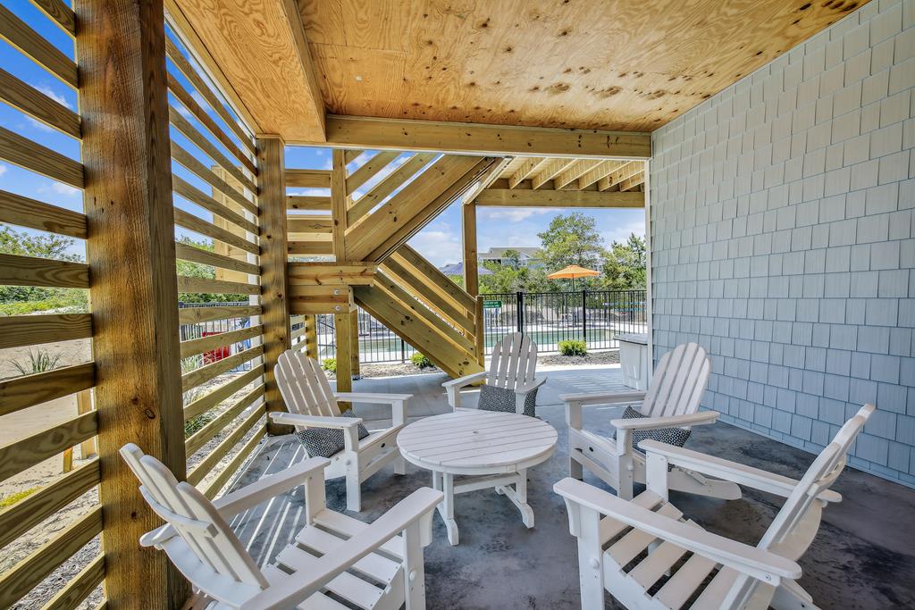 Unwind in your private covered patio with stylish Adirondack seating, framed by warm wood beams and natural light—ideal for morning coffee or evening conversation.