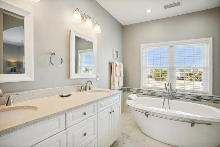 Unwind in your spa-like bathroom featuring a luxurious soaking tub and dual vanities. Soft natural light streams through the window, creating the perfect retreat after a day of adventure.