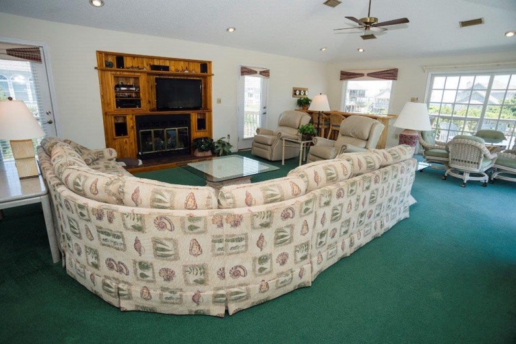 Unwind in this spacious living area where natural light pours through expansive windows, perfect for relaxing together after days at the beach.