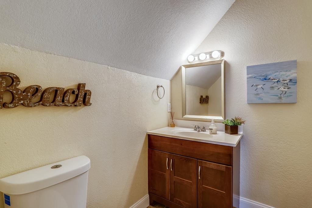 Freshen up in your bright bathroom with vanity lighting, coastal art, and thoughtful touches that make you feel right at home by the beach.