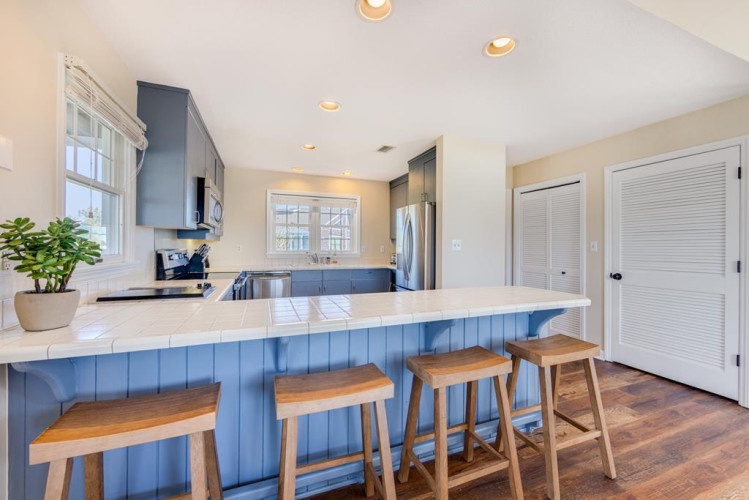 Gather around the coastal-inspired island for morning coffee or casual meals—your fully equipped kitchen awaits your culinary adventures.