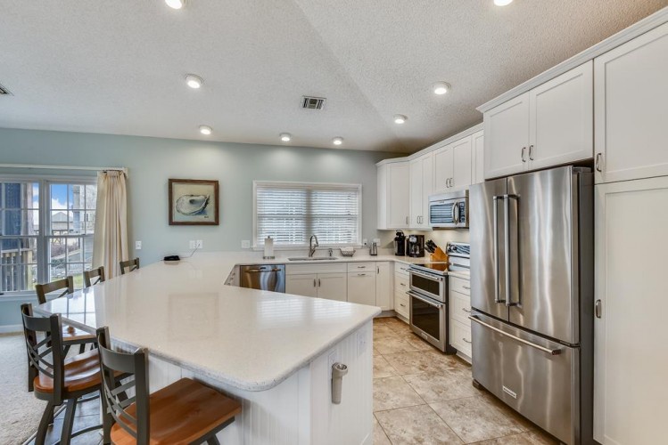 Prepare meals together in this bright, fully equipped kitchen with stainless appliances, ample counter space, and a convenient island for morning coffee or evening appetizers.