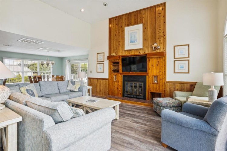 Settle into plush seating around a warm fireplace and enjoy your favorite shows on the flat-screen TV in this cozy living room where natural light flows through large windows.