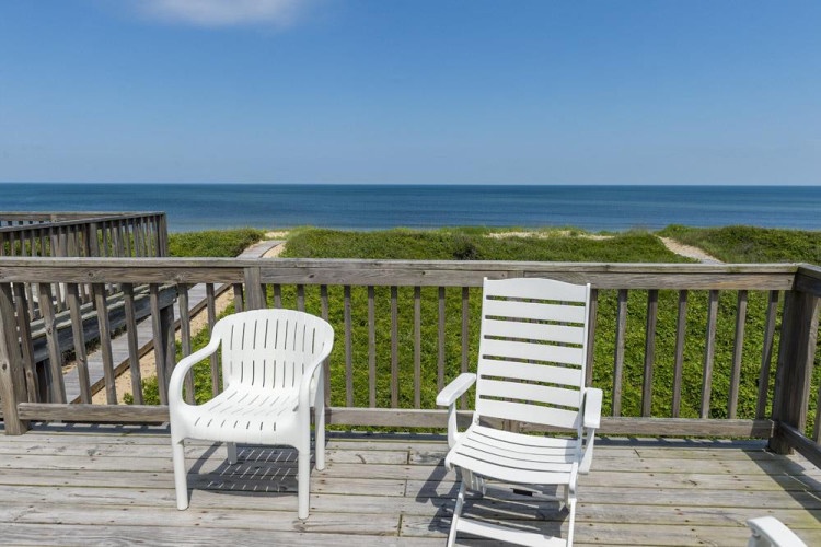 A prime beachfront location where the property sits along a scenic stretch of coast with direct beach access paths and sweeping ocean vistas.