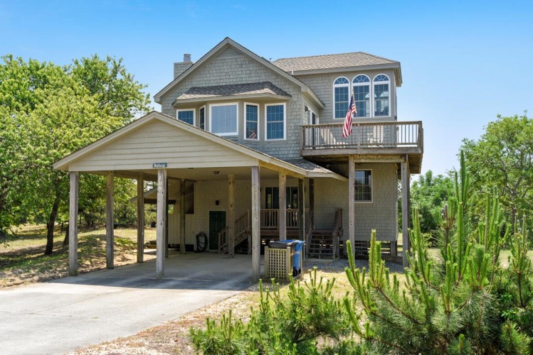A coastal retreat with spacious covered parking, multiple decks, and natural landscaping nestled among lush greenery—your perfect getaway awaits.