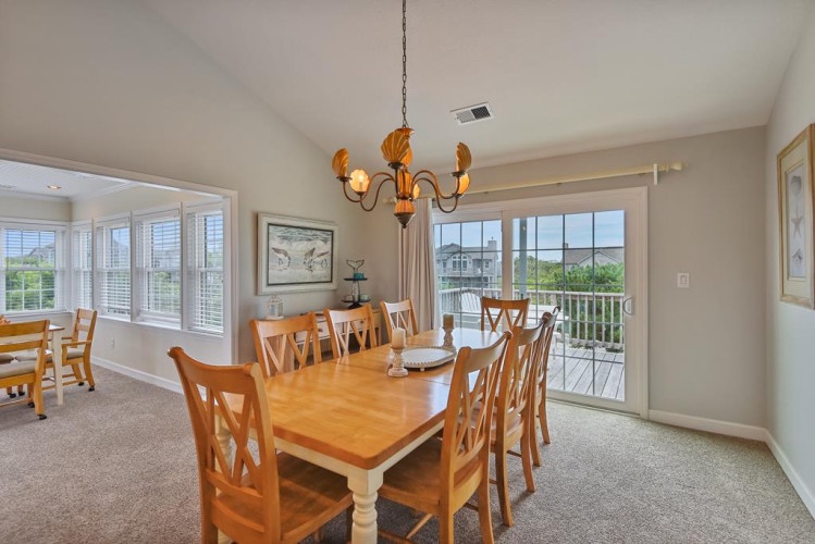 Gather around the table for meals and memories in this bright dining space, where large windows and balcony access bring natural light and serene views to your dining experience.