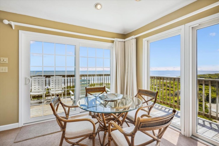 Savor morning coffee or evening meals at this cozy dining spot overlooking the ocean. Floor-to-ceiling windows frame sweeping coastal views, inviting sea breezes and sunlight into your space.