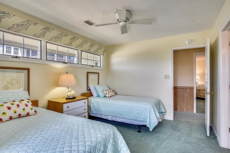 Enjoy restful nights in this bright, serene bedroom featuring two cozy beds, soft linens, and refreshing natural light. Perfect for families or friends traveling together.