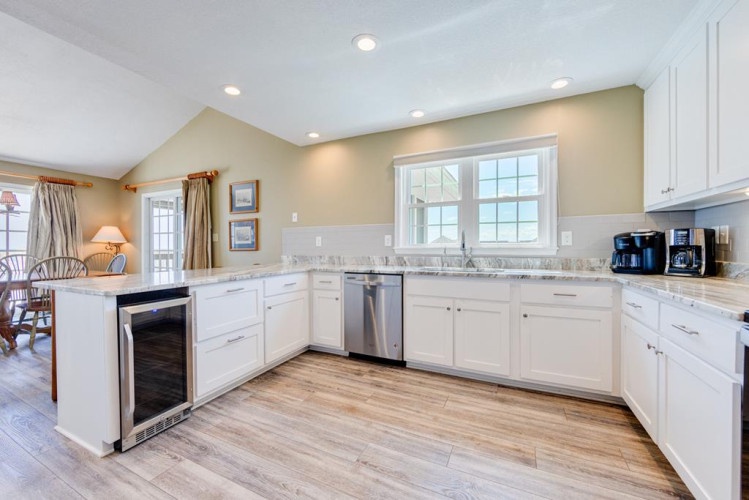 Prepare your favorite meals in this bright kitchen with gleaming white cabinetry, granite countertops, and modern stainless appliances. A warm space opens to the dining area, inviting you to gather and create memories over home-cooked dishes.