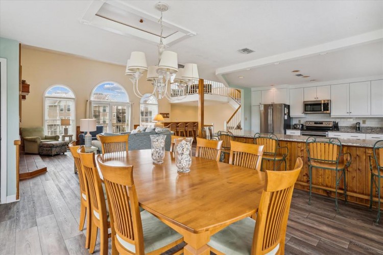 Step into your spacious vacation haven where dining, cooking, and lounging blend seamlessly. Natural light pours through arched windows, illuminating the open floor plan and inviting you to gather with loved ones.