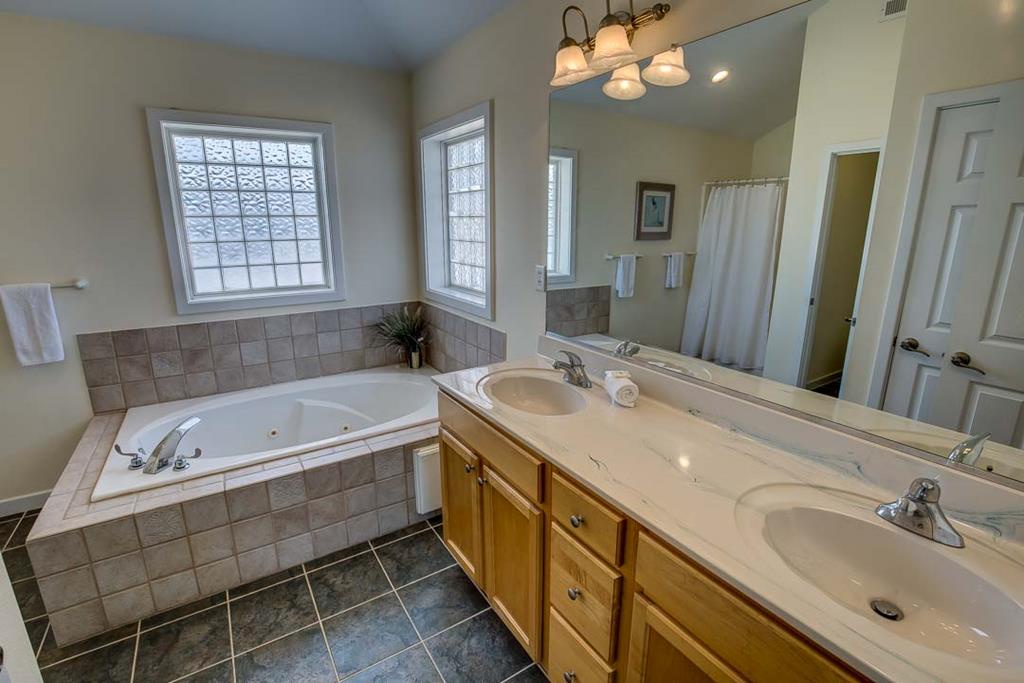 Soak your cares away in your private jetted tub, or freshen up at the spacious double vanity with plenty of natural light and warm, welcoming touches.