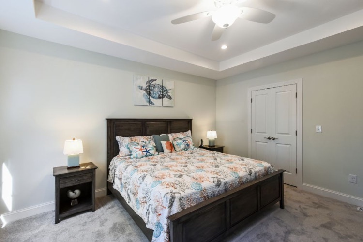 Settle into your peaceful retreat, where coastal-inspired touches and a plush bed invite restful nights beneath the soft glow of a ceiling fan.