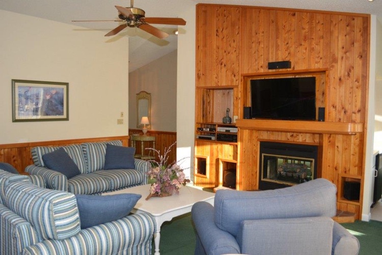 Relax in your cozy living room with comfortable seating, a warm fireplace, and entertainment center—your perfect mountain retreat after a day of adventure.