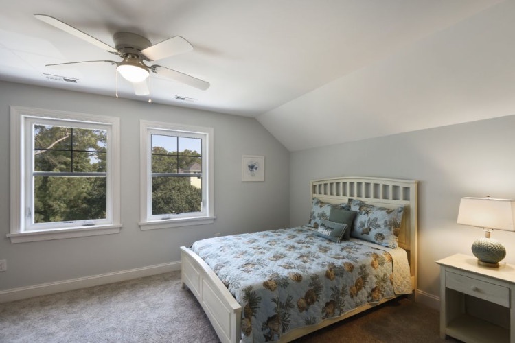 Your peaceful retreat features a ceiling fan and bright windows framing leafy views. Settle into the plush bed and let the gentle breeze lull you to sleep.