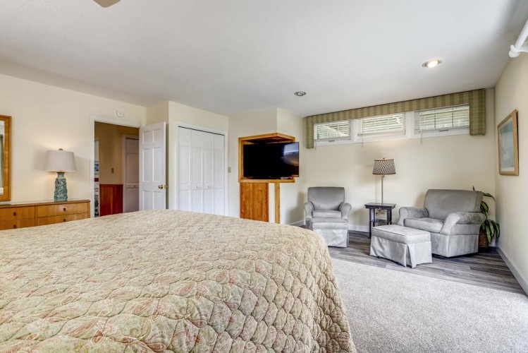 Unwind in your peaceful bedroom suite with cozy seating, a flat-screen TV, and plenty of natural light streaming through the windows.