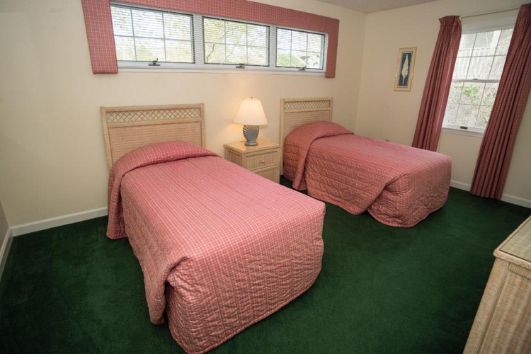 Rest easy in this bright twin bedroom, where two comfortable beds await after your adventures. Natural light fills the space, creating a welcoming retreat for your group or family.