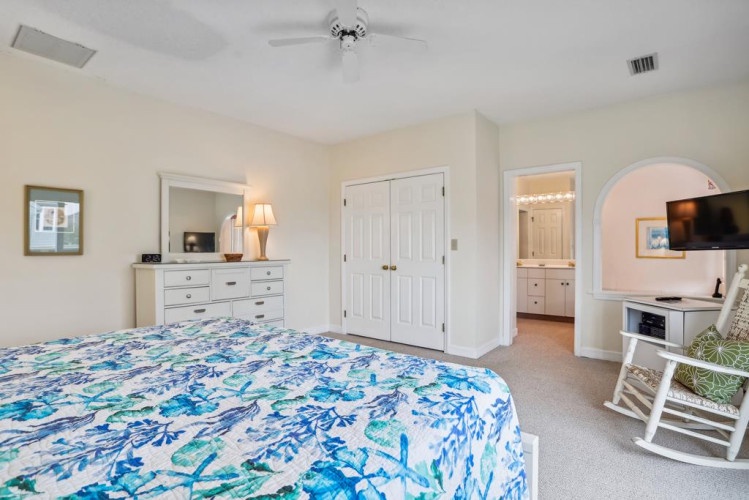 Your tranquil retreat features a ceiling fan, dresser with mirror, and convenient ensuite access for ultimate comfort and privacy during your coastal escape.