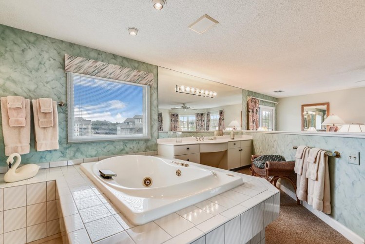 Unwind in your private spa-like bathroom with a spacious jetted tub, dual vanities, and serene natural light streaming through large windows.