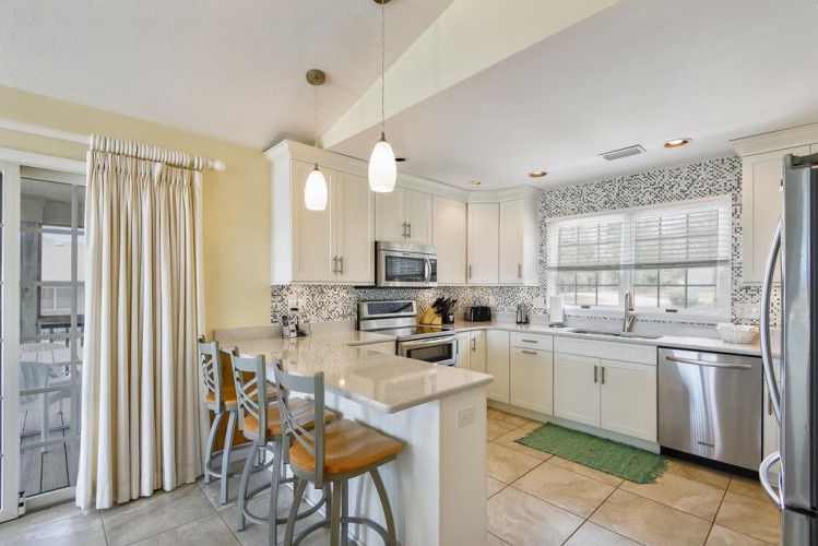 Your bright, airy kitchen awaits with gleaming countertops, modern appliances, and breakfast bar seating—perfect for preparing meals and gathering with loved ones.
