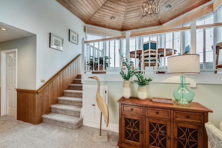 Step into a serene coastal retreat where vaulted wood ceilings and sunlit windows create an airy, welcoming sanctuary perfect for your island getaway.