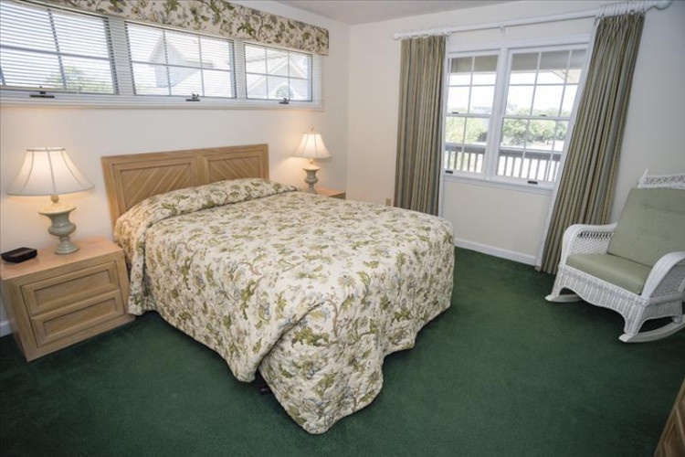 Slip into crisp linens and unwind in your cozy retreat, where soft lamplight and a charming rocking chair invite peaceful evenings after your day's adventures.