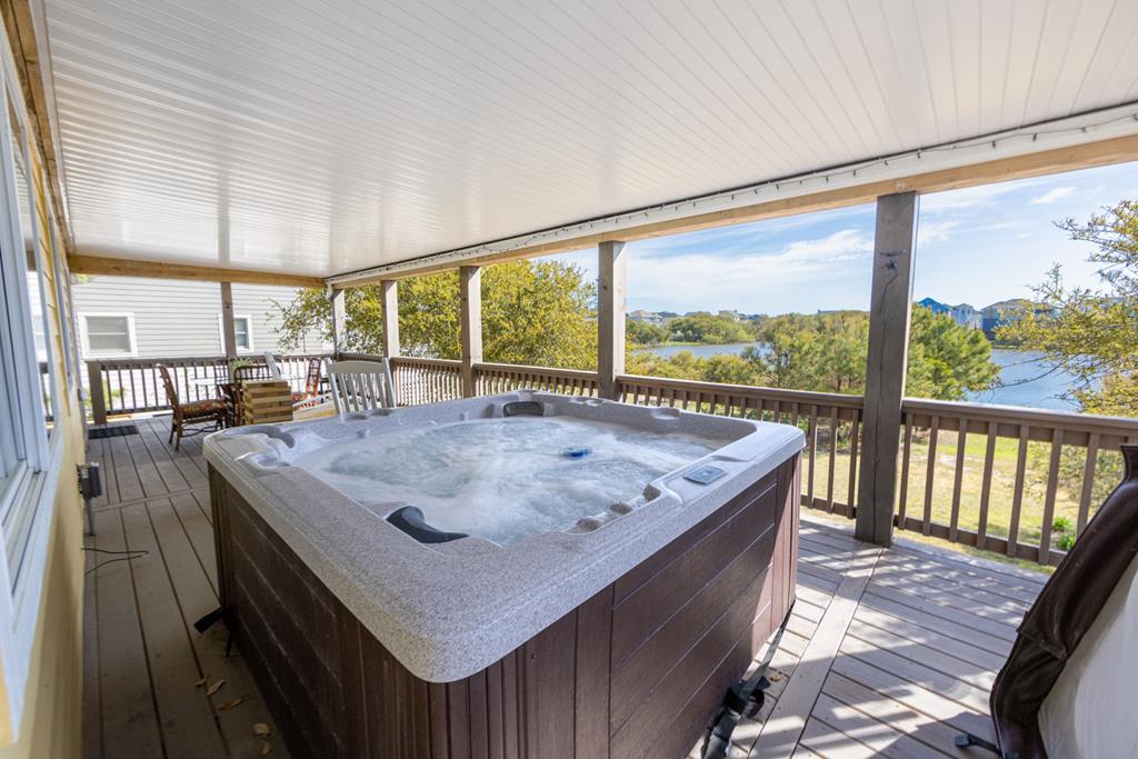 Soak away your cares in your private hot tub while taking in stunning lake and tree-lined views from this covered deck—your perfect spot for morning coffee or evening relaxation.