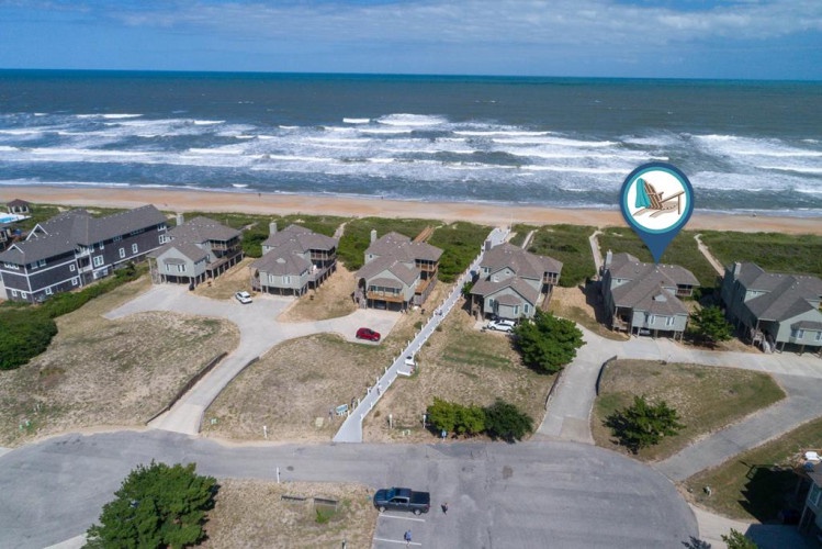 Coastal community of vacation homes situated directly along the sandy beachfront, offering easy access to the ocean. The property is marked and located within this seaside neighborhood.