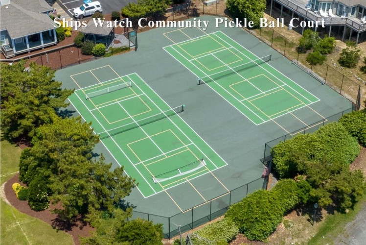 Aerial view of the Ships Watch Community Pickleball Courts, featuring three well-maintained courts surrounded by trees and residential properties in a peaceful neighborhood setting.