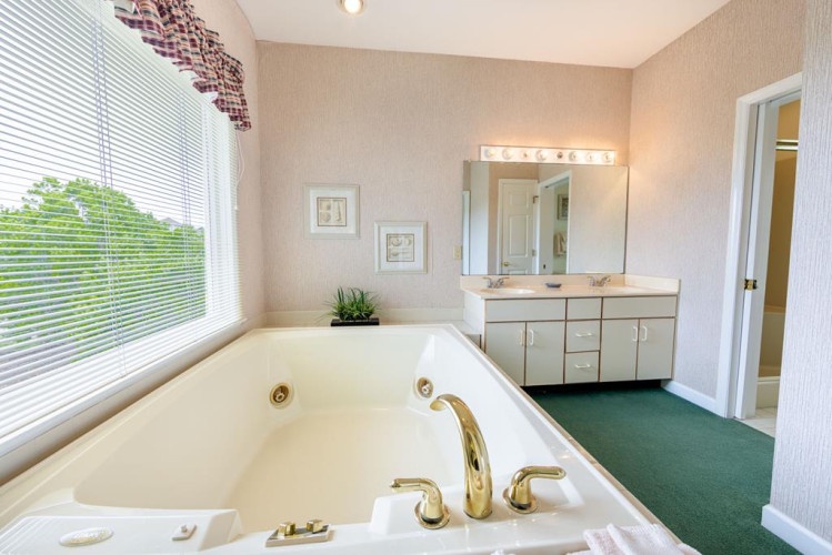 Sink into the oversized soaking tub and let the jets melt your stress away. With natural light streaming through the window and a peaceful garden view, your private spa awaits.