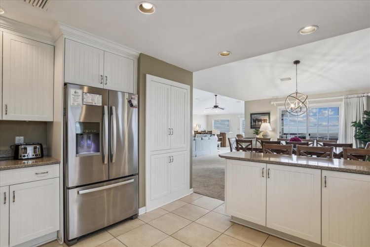 Prepare your favorite meals in this bright, fully-equipped kitchen with stainless appliances and ample counter space, flowing seamlessly into the dining area and beyond.