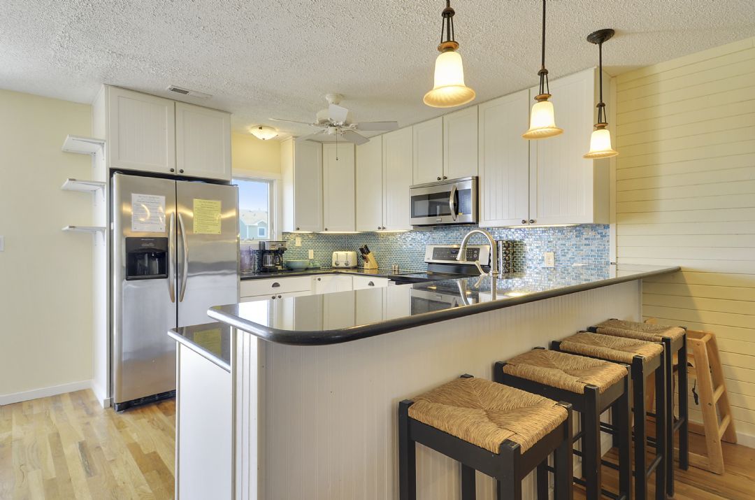 Your fully equipped kitchen awaits with modern appliances, sleek countertops, and stylish pendant lighting. Pull up a seat at the island and enjoy your morning coffee in this bright, inviting space.