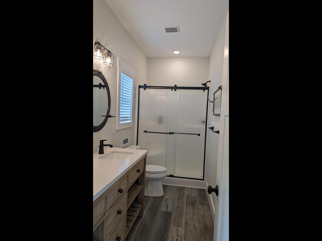 Your private bathroom features modern farmhouse style with a spacious walk-in shower, elegant fixtures, and plenty of natural light for a refreshing start to your day.