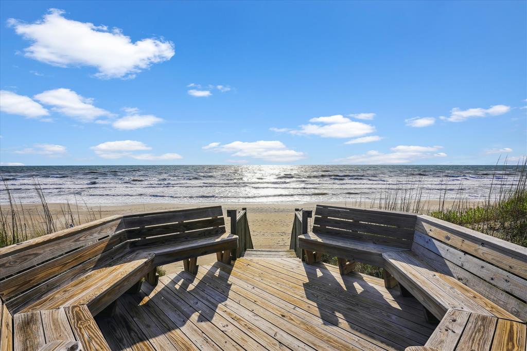 Sandy beach access with built-in benches provides your private path to the ocean, where waves and coastal breezes await.