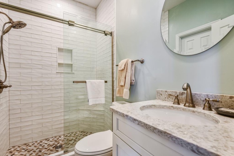 Refresh after your day in this serene bathroom, featuring a walk-in shower, granite vanity, and calming coastal tones designed for your comfort.