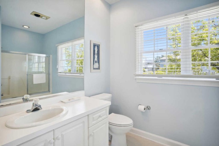 Light-filled bathroom with soft blue tones, clean white fixtures, and a glass-enclosed shower for your refreshing morning routine.