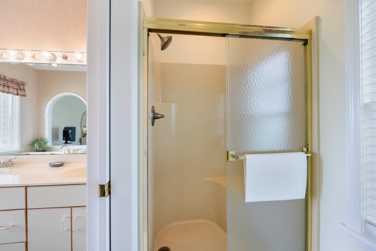 Step into your bright, well-appointed bathroom featuring a spacious walk-in shower with modern fixtures. Fresh towels await your arrival, and the thoughtful layout ensures a comfortable, relaxing stay.